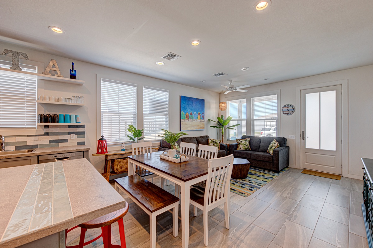 Your open-concept living space blends kitchen, dining, and relaxation into one welcoming retreat with coastal touches and natural light.