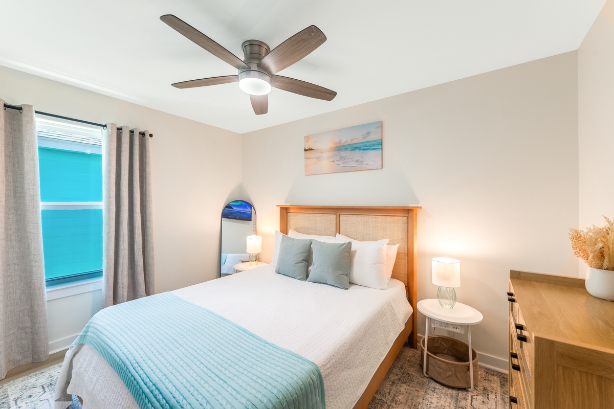 Drift into peaceful sleep in your coastal-inspired bedroom with ocean artwork, soft linens, and gentle ceiling fan breeze.
