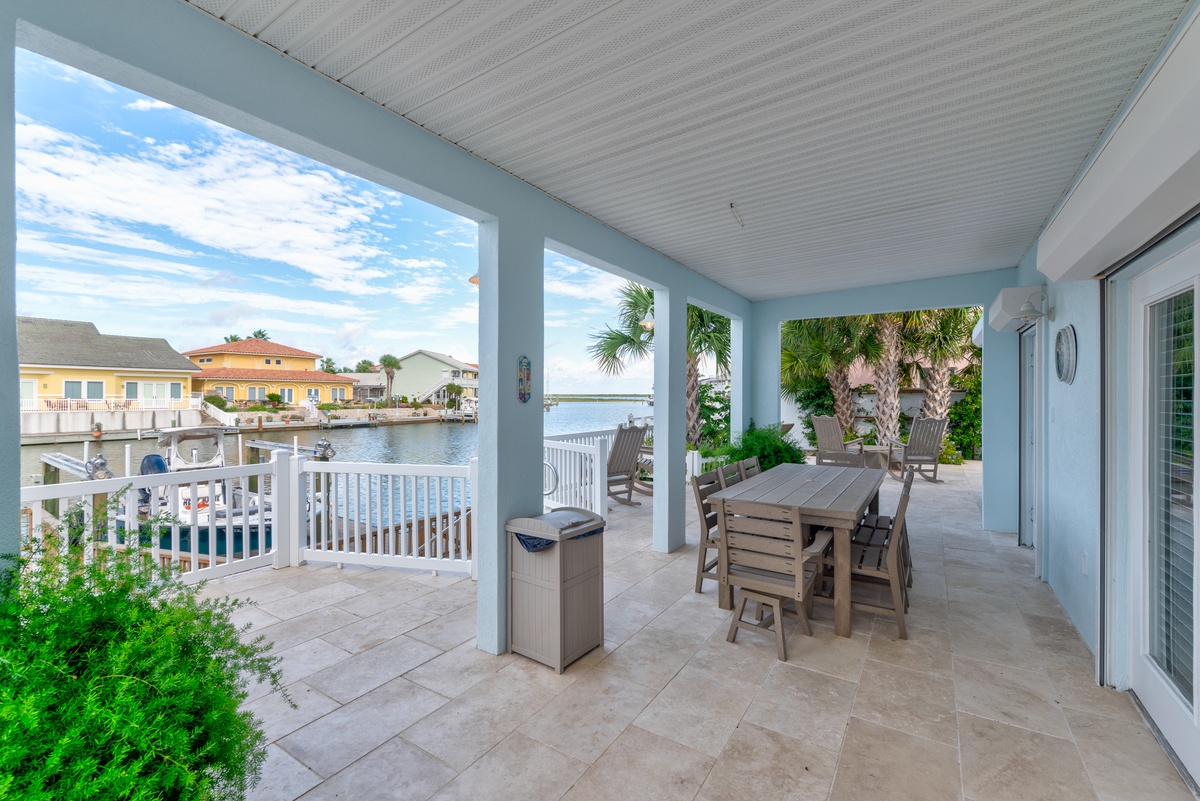 Relax on your private covered patio overlooking serene canal waters, where tropical palms frame your dining space and waterfront views stretch beyond. Perfect for morning coffee or sunset dinners.