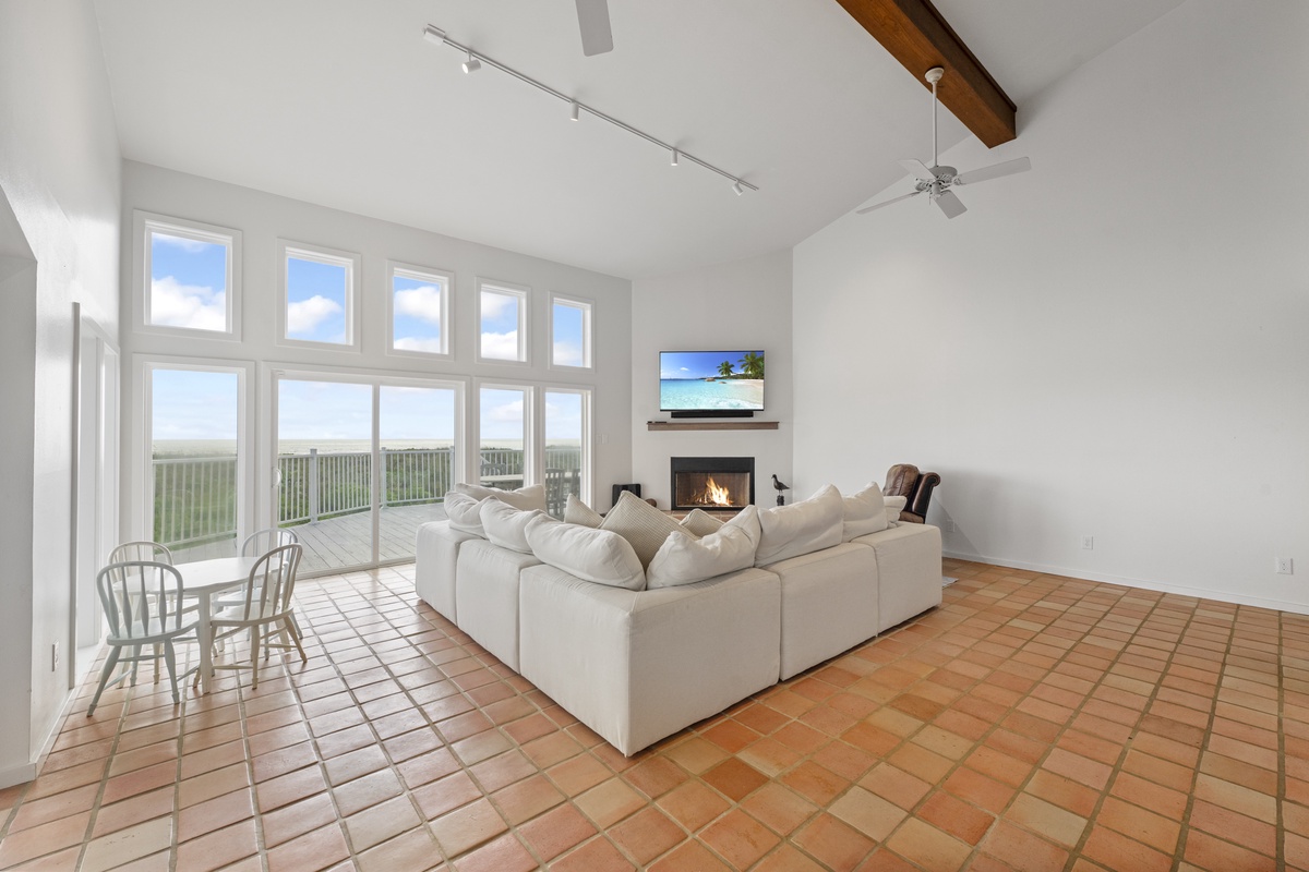 Relax in your bright living space with panoramic windows, cozy fireplace, and sweeping views that stretch endlessly beyond.