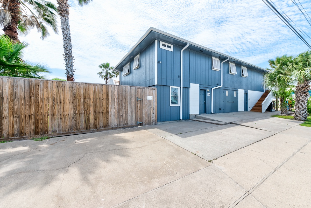 Charming coastal property with tropical palm trees and convenient parking area for easy arrival.