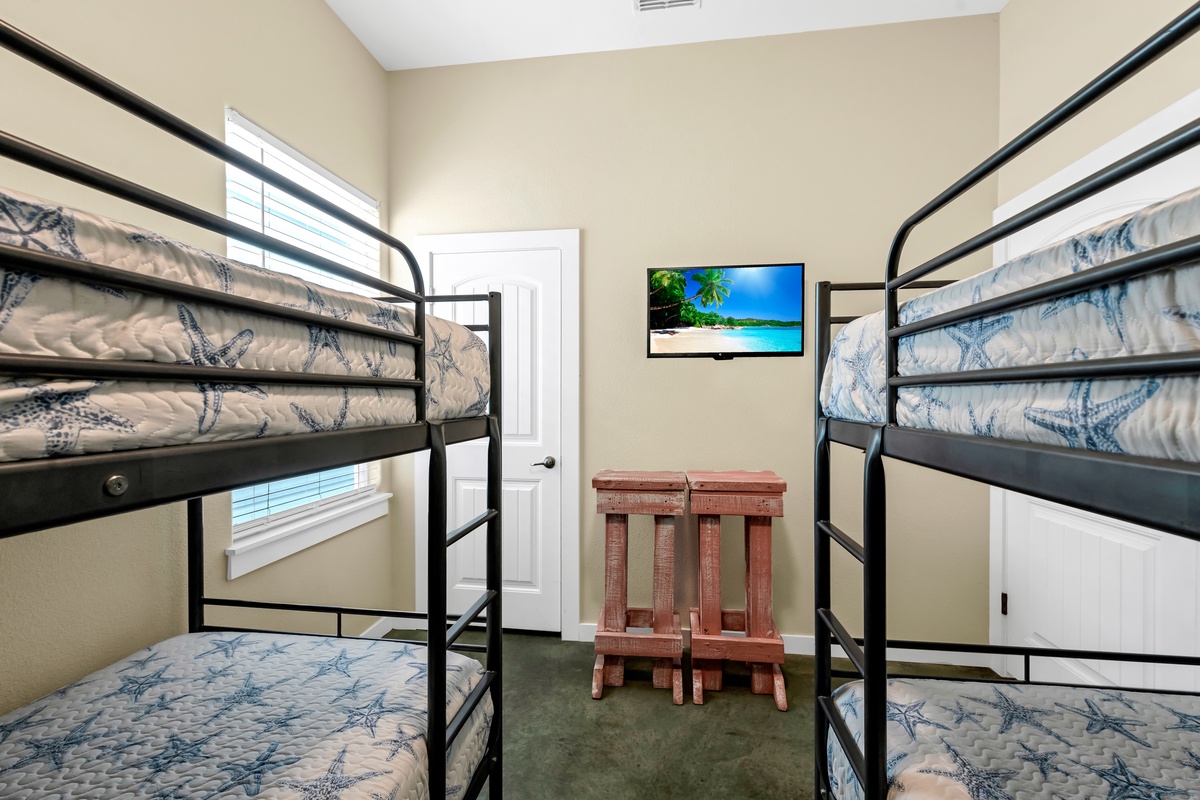 Your cozy bunk room sleeps four comfortably with sturdy metal frames, soft nautical bedding, and your own wall-mounted TV for entertainment.