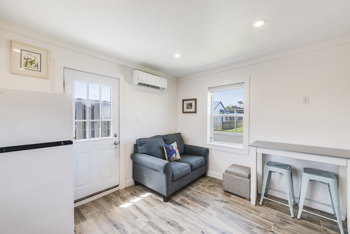 Relax in this bright, open living space featuring cozy seating, a breakfast nook, and all the comforts of home after a day at the beach.