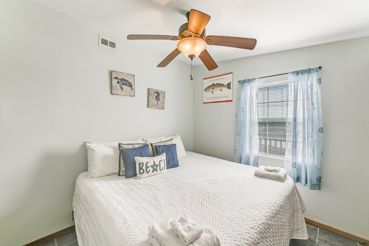 Wake up refreshed in your coastal-themed bedroom with crisp linens and ocean breeze from the ceiling fan.