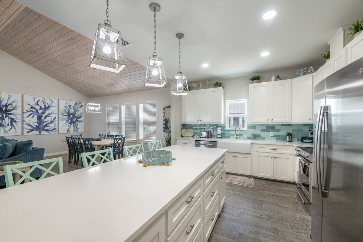 Your spacious coastal kitchen invites culinary adventures with gleaming countertops, modern appliances, and charming sea-inspired touches throughout this bright, airy space.