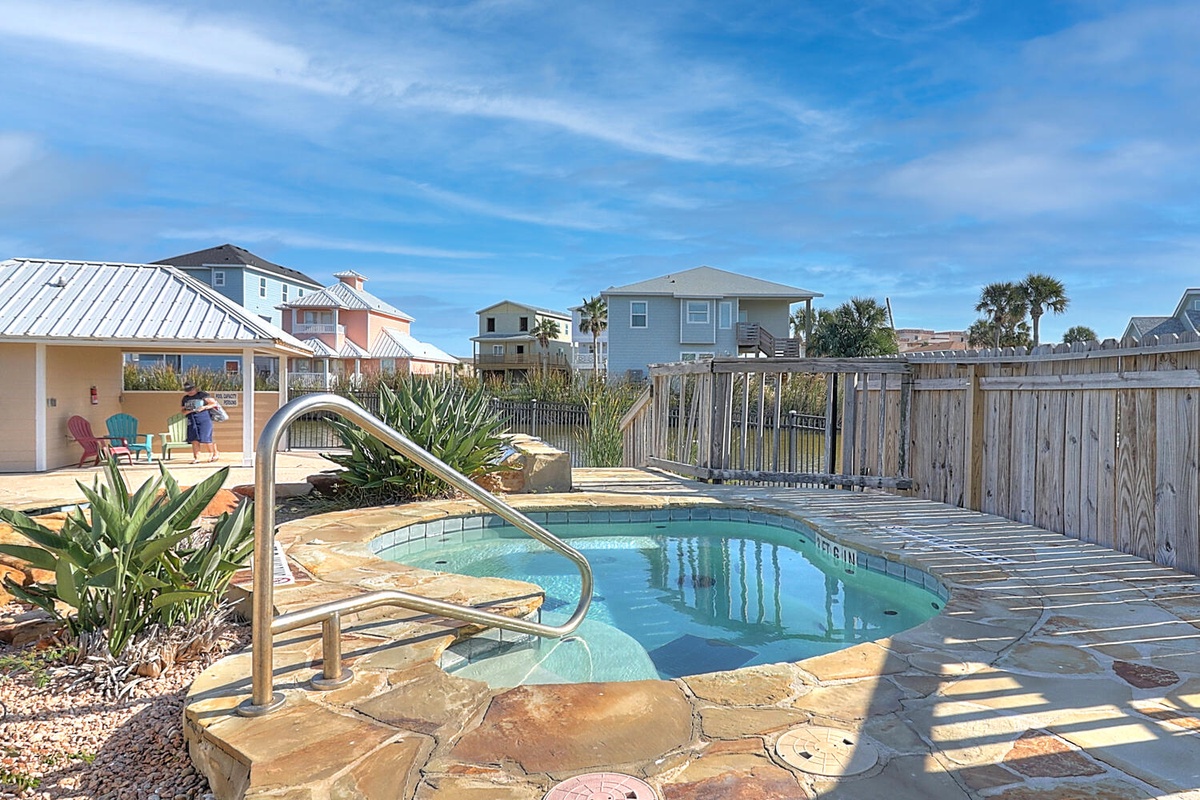 Your private pool sanctuary awaits with sunny stone decking, tropical plants, and colorful outdoor seating perfect for relaxing poolside days.