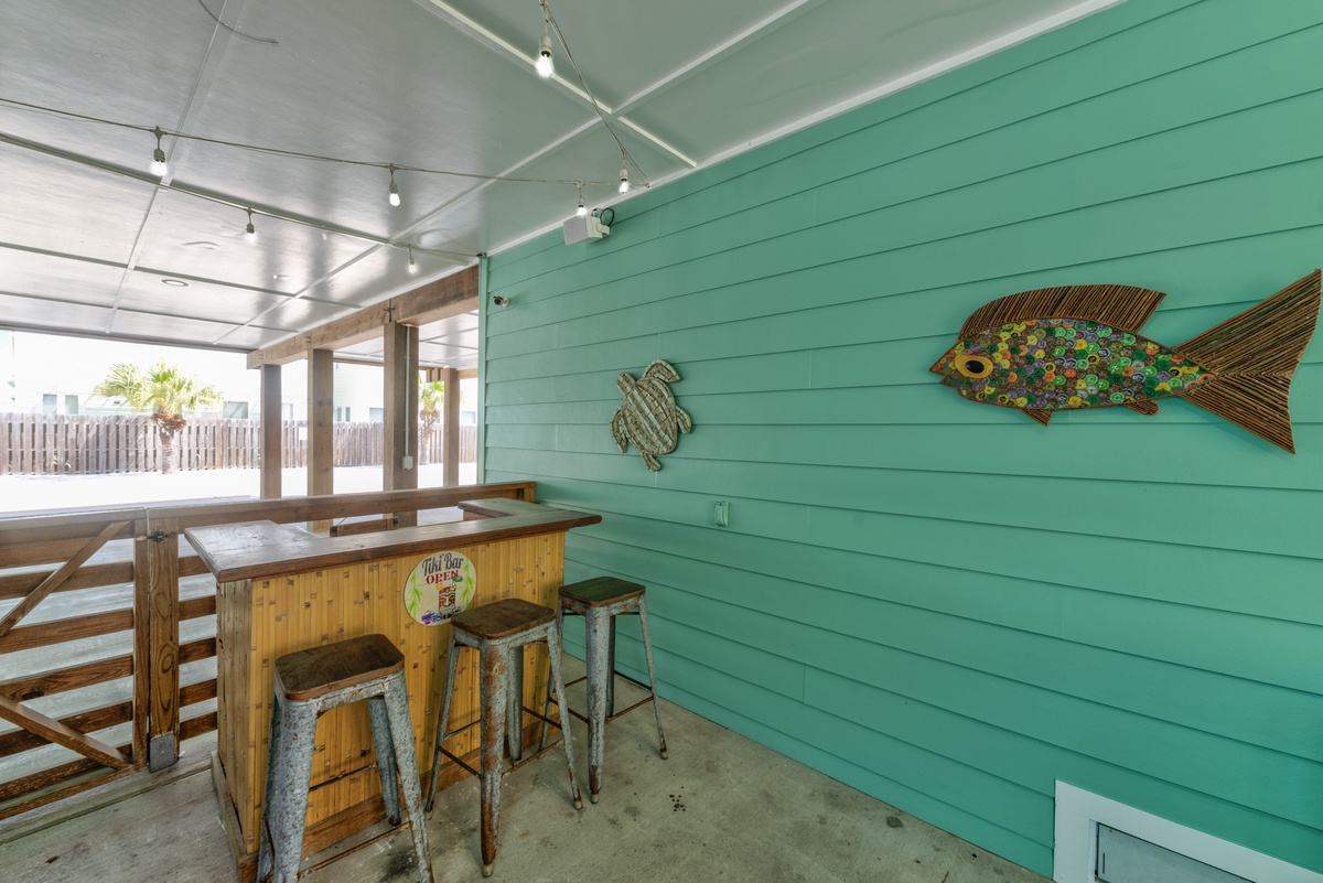 Your own tropical tiki bar awaits with bright coastal charm, rustic seating, and playful fish art—perfect for mixing drinks and making vacation memories.