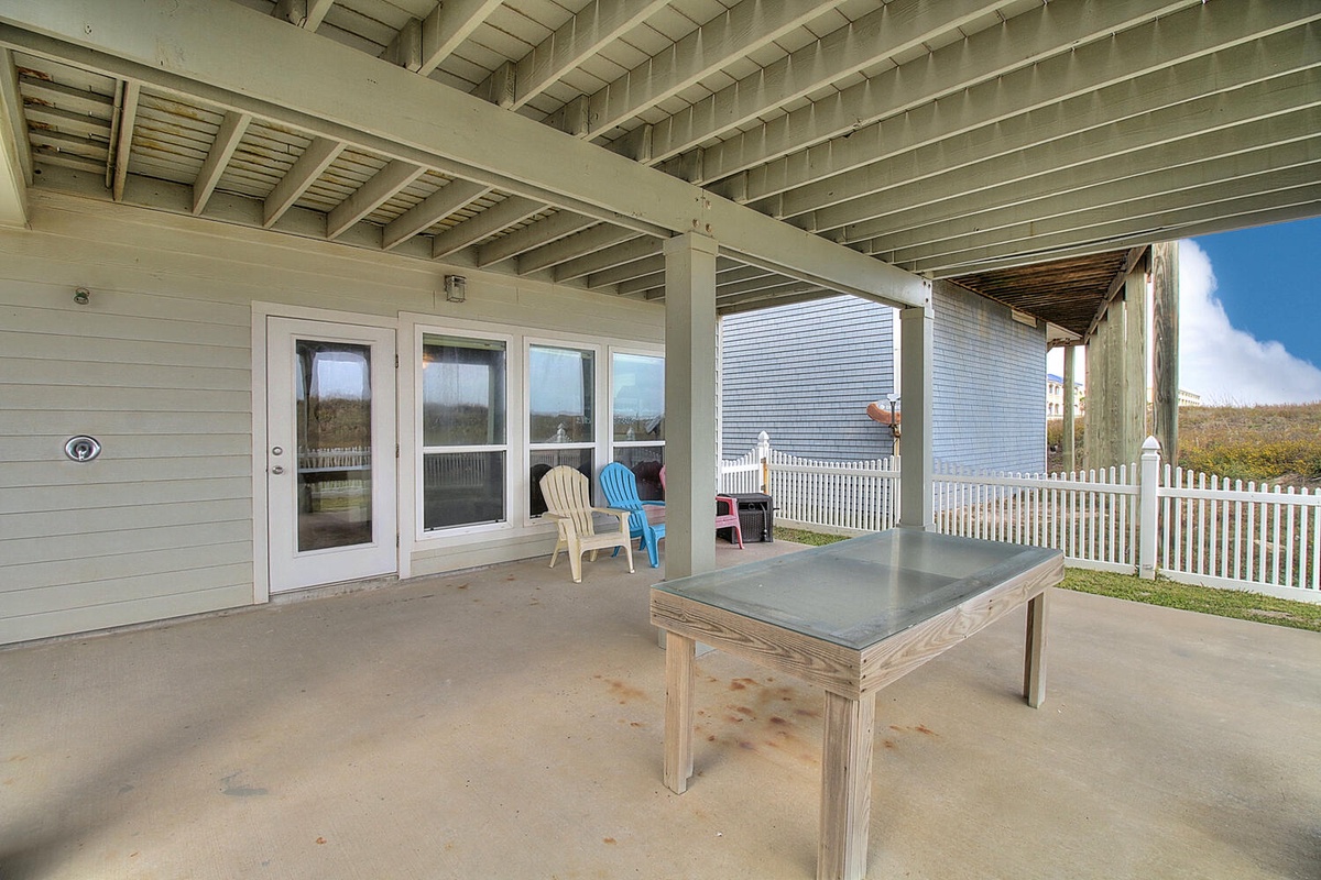 Unwind on your covered patio with colorful seating and a sturdy table, perfect for morning coffee or evening gatherings.