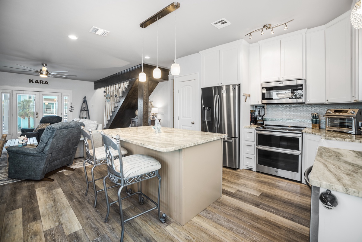 Your open-concept kitchen flows seamlessly into the living space, featuring granite countertops, stainless steel appliances, and an island perfect for morning coffee.