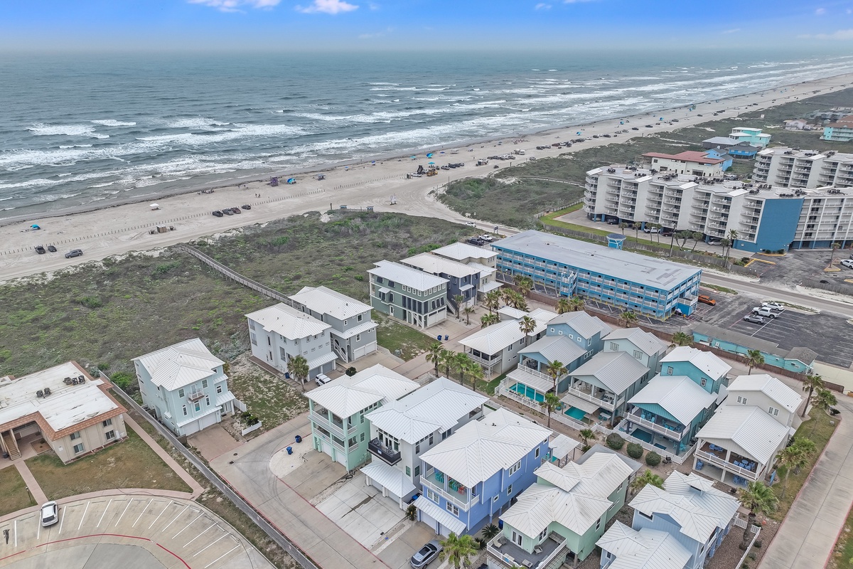 Coastal community featuring modern beach houses with direct access to pristine sandy shores and rolling ocean waves.