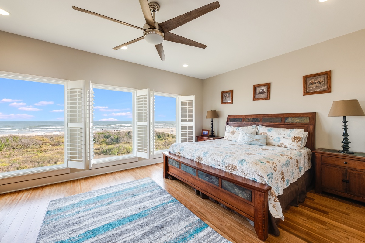 Wake up to stunning ocean views from your comfortable bedroom, where coastal breezes flow through plantation shutters and hardwood floors add warmth to your seaside retreat.