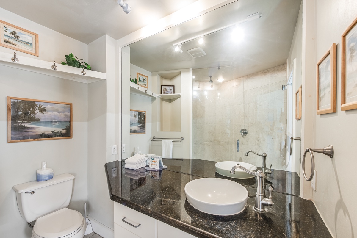 Step into your private spa-like bathroom featuring a luxurious granite vanity, vessel sink, and spacious glass shower.