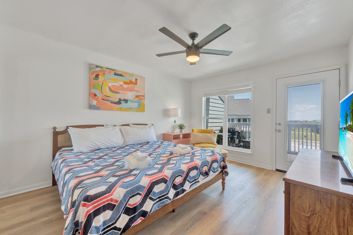 Drift off in this bright bedroom where colorful art meets comfort, complete with ceiling fan and your private balcony for morning coffee.