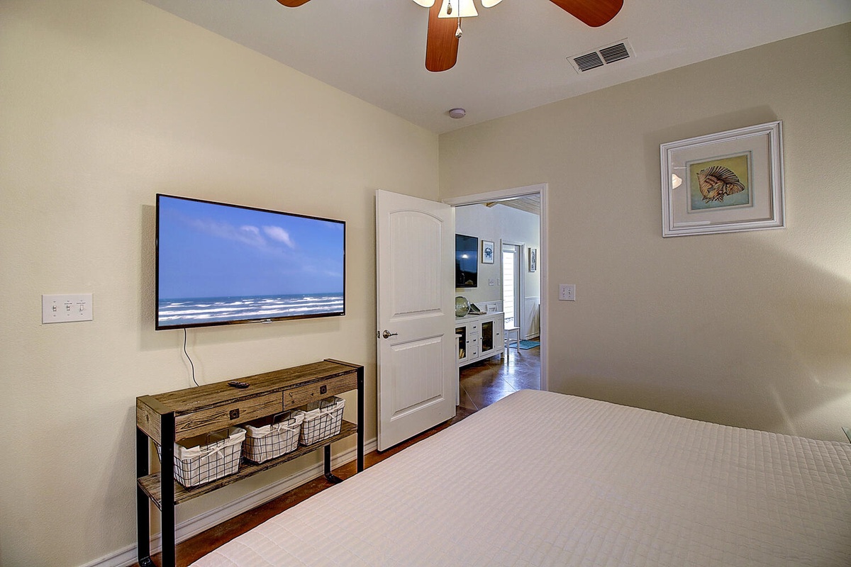 Unwind in your cozy bedroom with beach scenes on the wall-mounted TV and rustic storage beneath.
