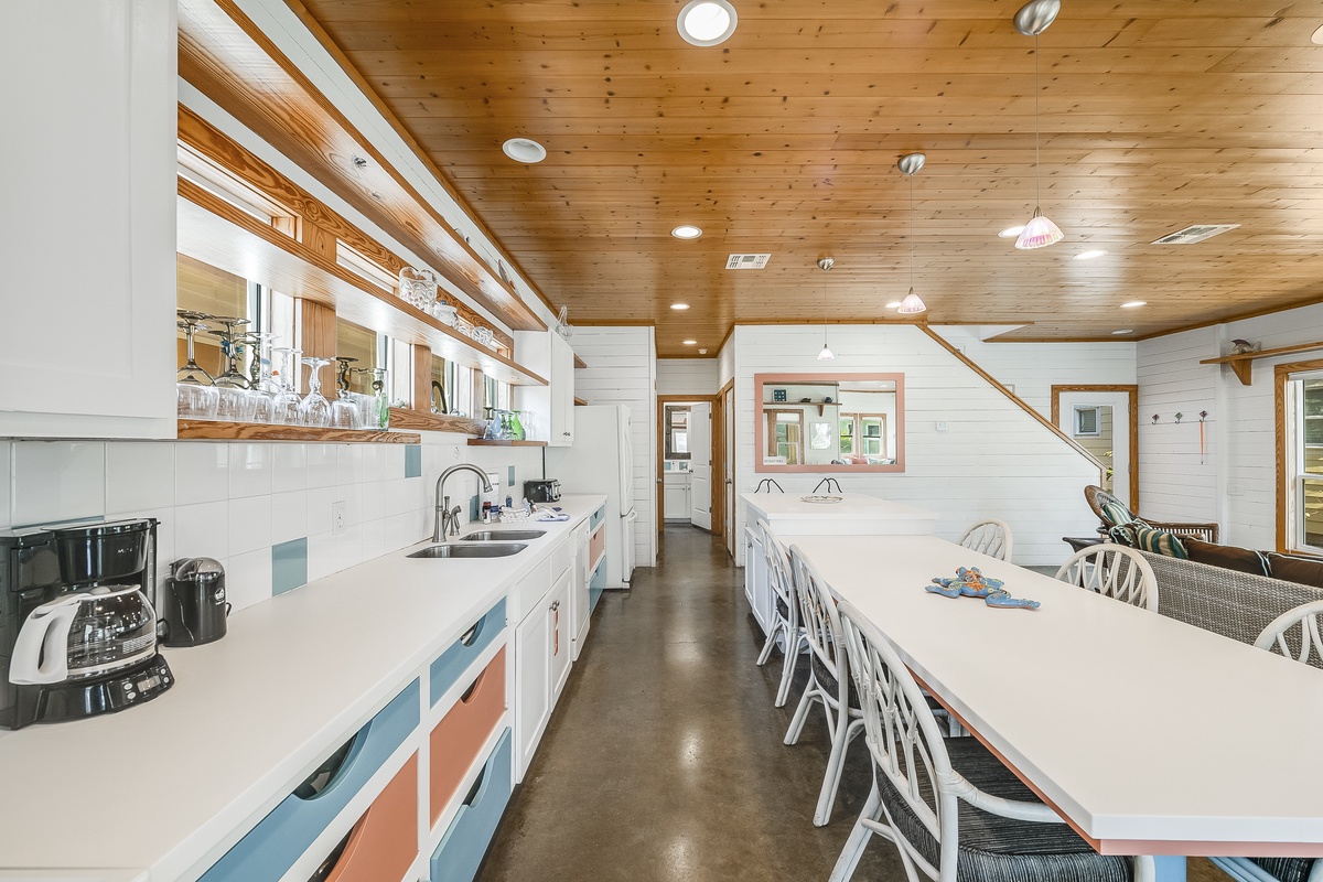 Your spacious kitchen invites group cooking with gleaming counters, modern appliances, and a dining table perfect for sharing meals together.