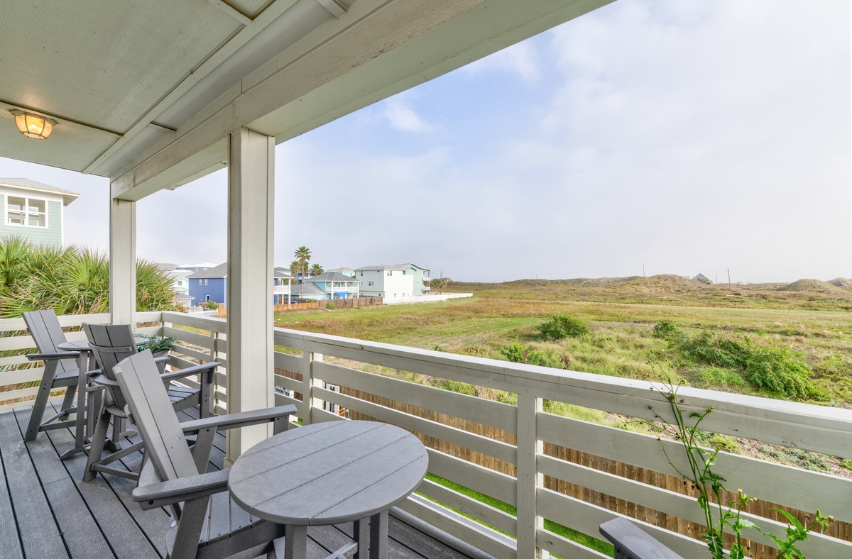 Relax on your private balcony with sweeping views over rolling coastal hills and charming seaside homes.