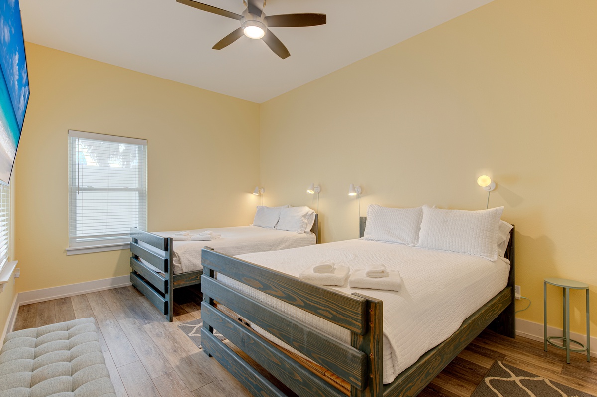 Drift off in your comfortable bedroom featuring two cozy beds, gentle ceiling fan, and warm lighting for the perfect night's rest.