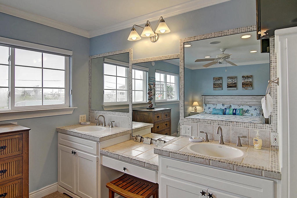 Your master bathroom offers dual sinks, elegant tile work, and a relaxing soaking tub where you can unwind after beach days.