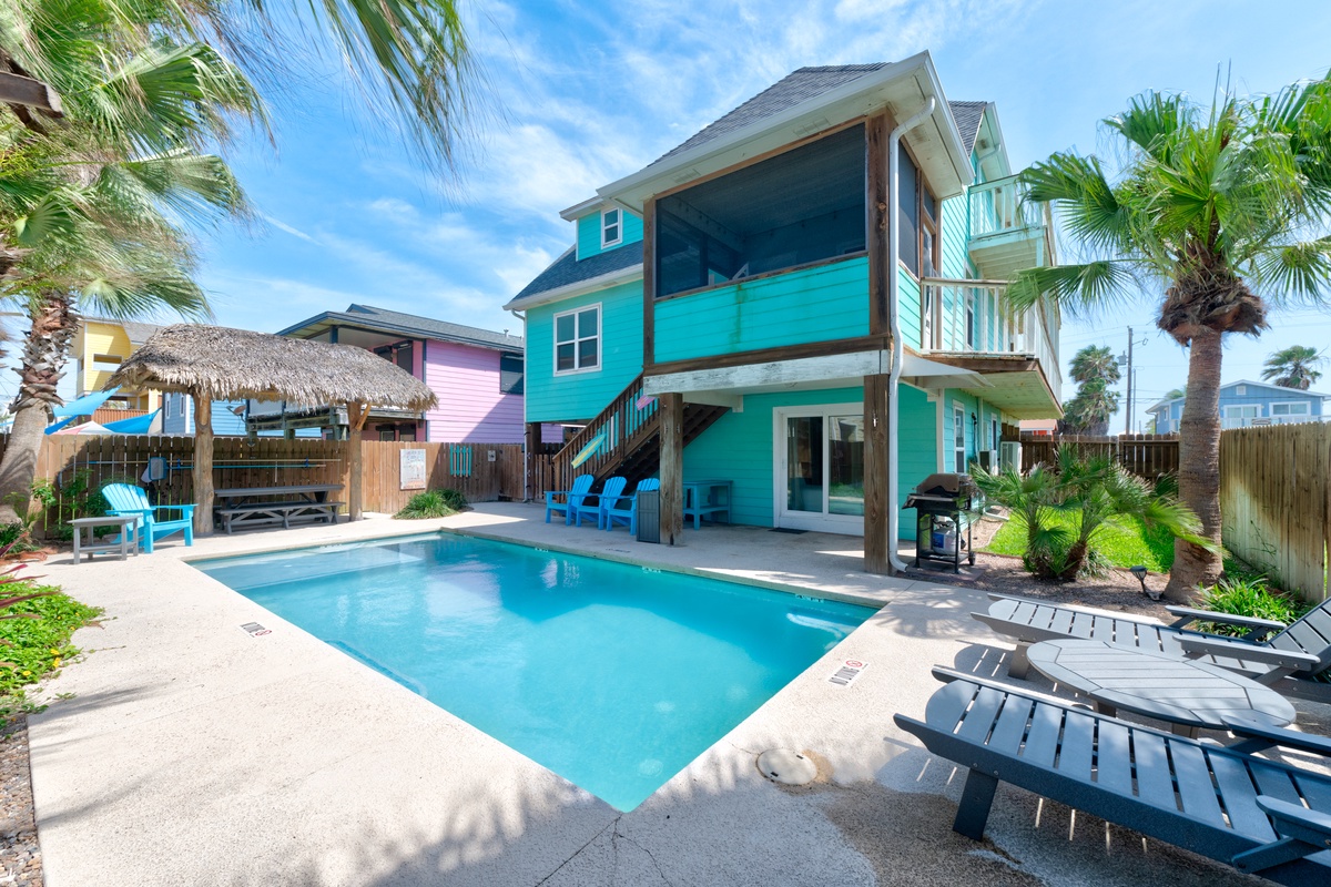 Vibrant beachside retreat with private pool surrounded by swaying palms and colorful coastal architecture in a tropical paradise setting.