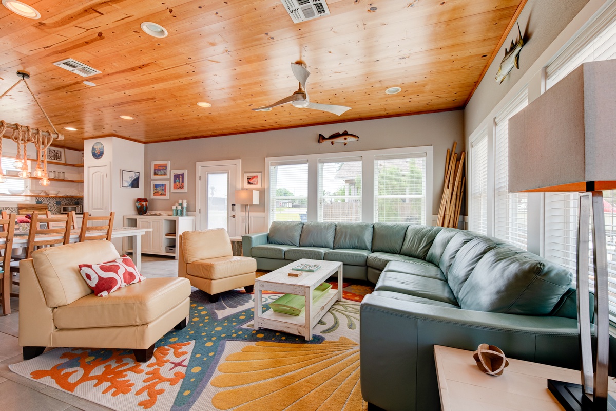 You'll love gathering with family in this spacious open-concept living area, where warm wood ceilings and comfortable seating create the perfect retreat.