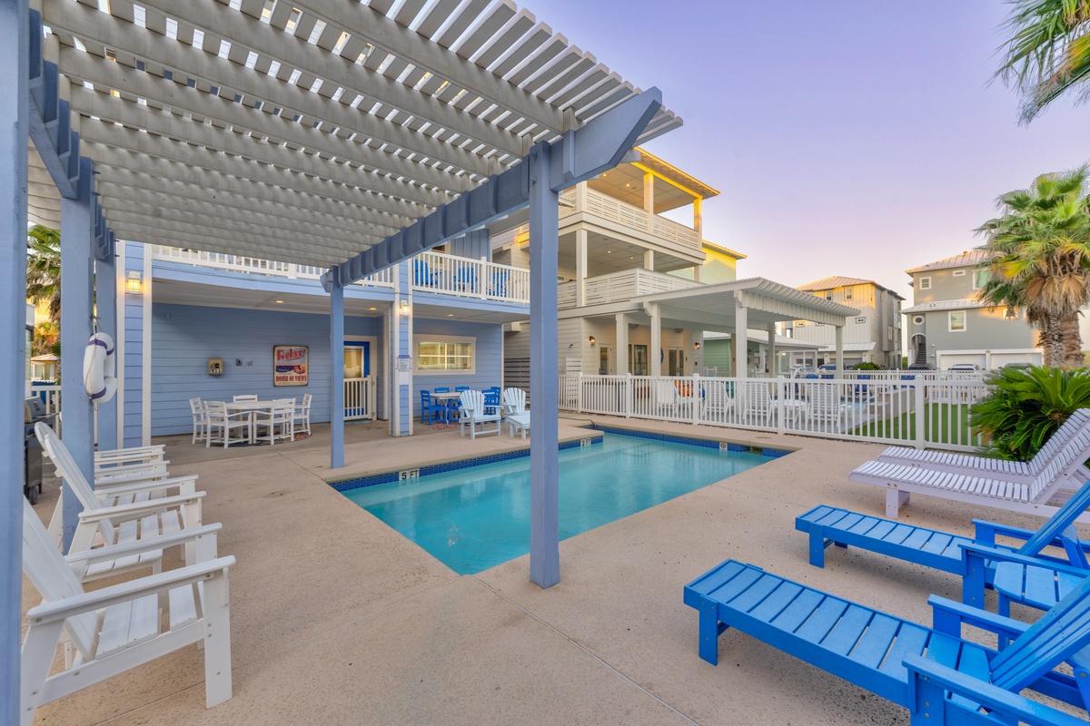 Your private pool oasis awaits with colorful lounge chairs and covered dining space for perfect poolside relaxation.