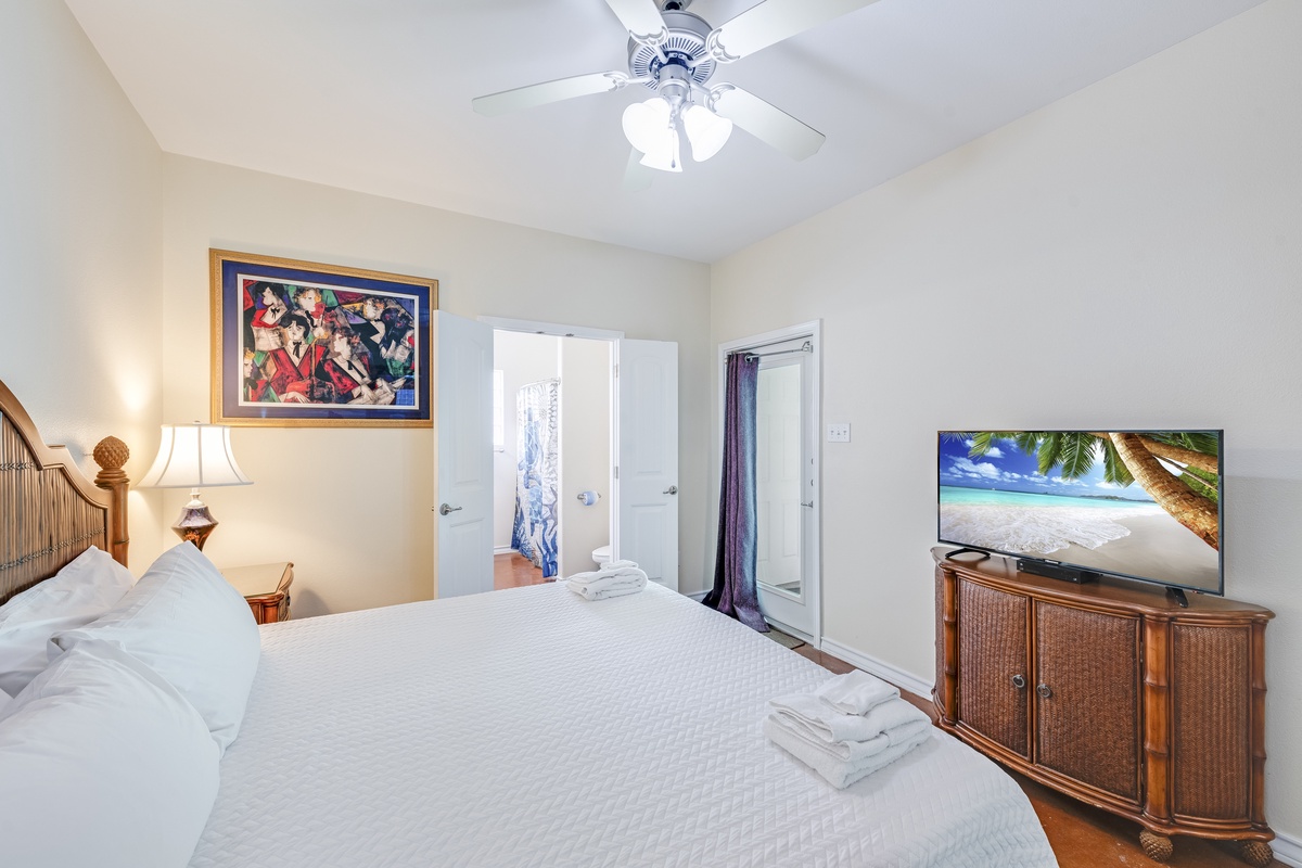 Relax in your serene bedroom with tropical touches, ceiling fan comfort, and entertainment ready for your evening unwind.