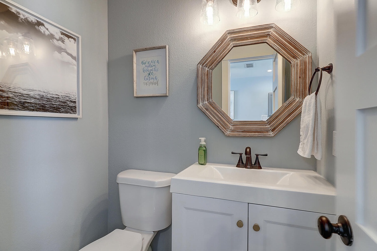 Refresh in your private powder room featuring coastal artwork and thoughtful touches that make you feel right at home.