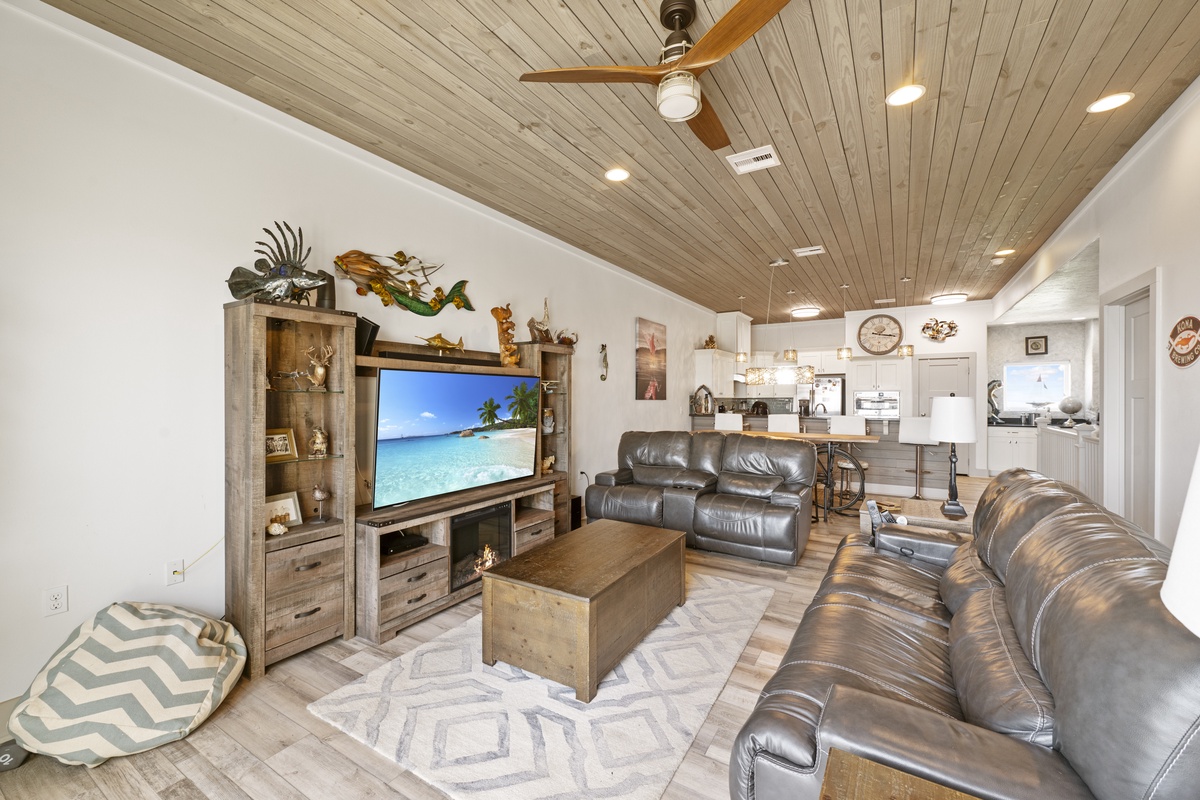 Relax in your spacious living room with comfortable leather seating and entertainment center, perfect for movie nights after beach days.