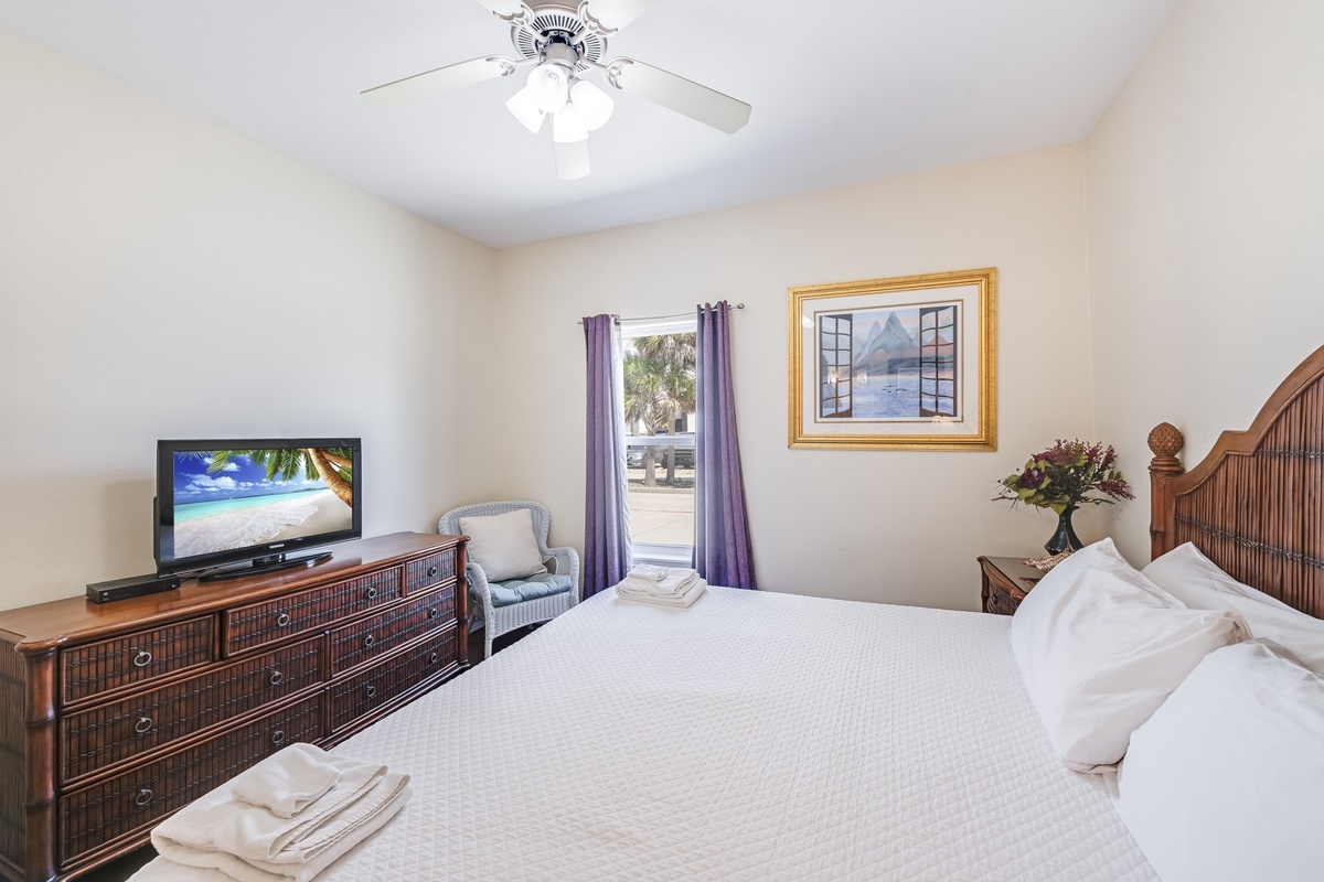 Unwind in your peaceful bedroom with crisp linens, tropical TV views, and gentle ceiling fan breezes creating the perfect retreat.
