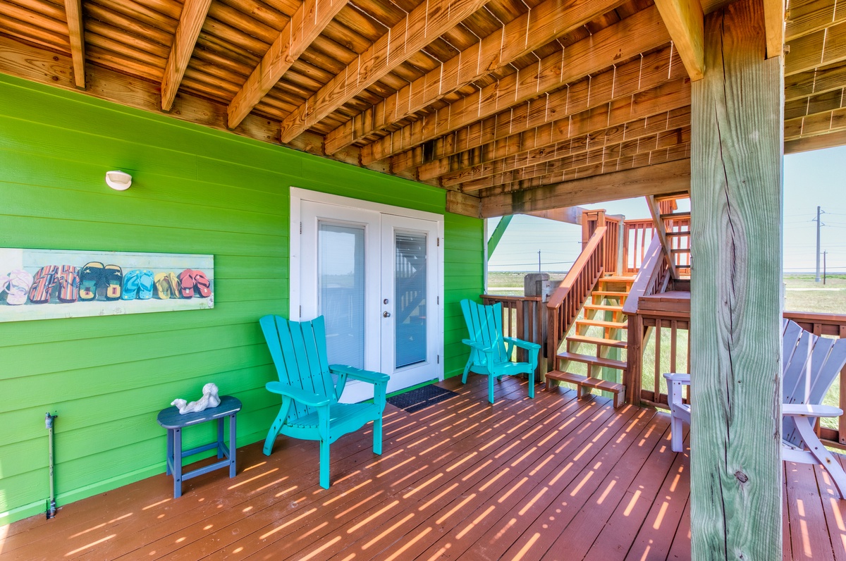 Relax in bright turquoise chairs on your private deck, where colorful beach vibes meet stunning coastal views.