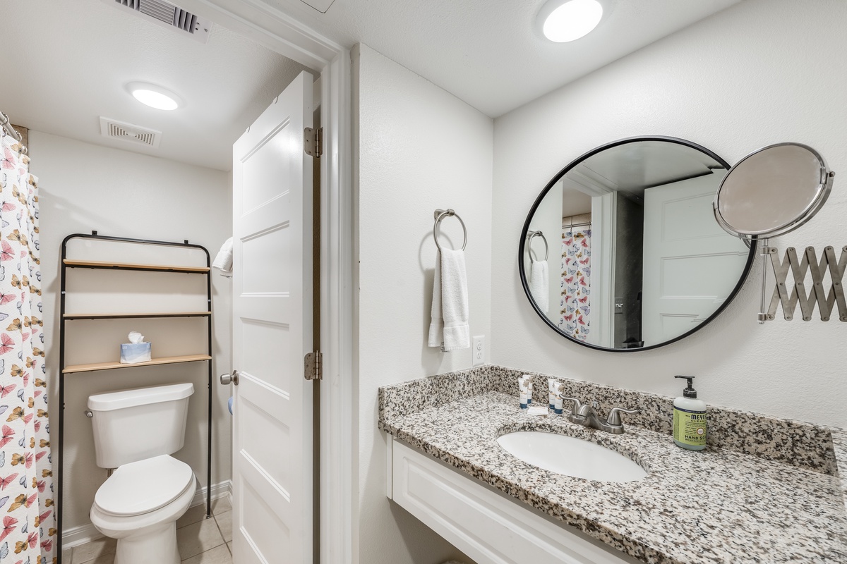 Refresh in your pristine bathroom featuring granite countertops, a spacious vanity, and thoughtful touches like premium amenities and fluffy towels.