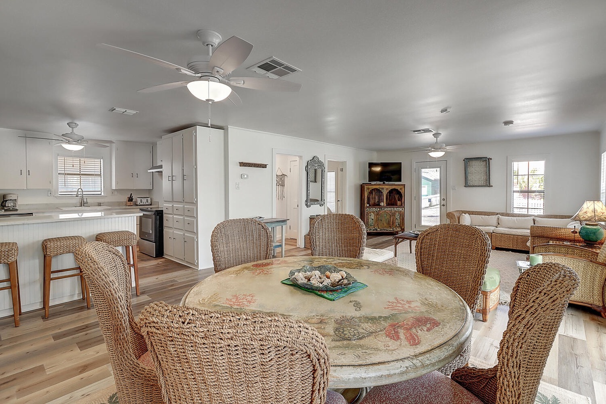 Your spacious dining area flows into the kitchen and living room, perfect for gathering around the charming weathered table.