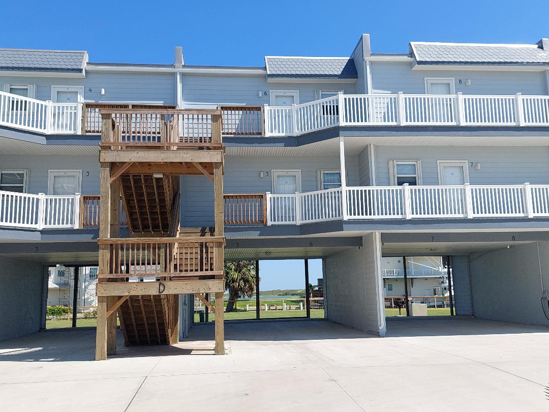 Multi-story coastal property with covered parking and private balconies for each unit.