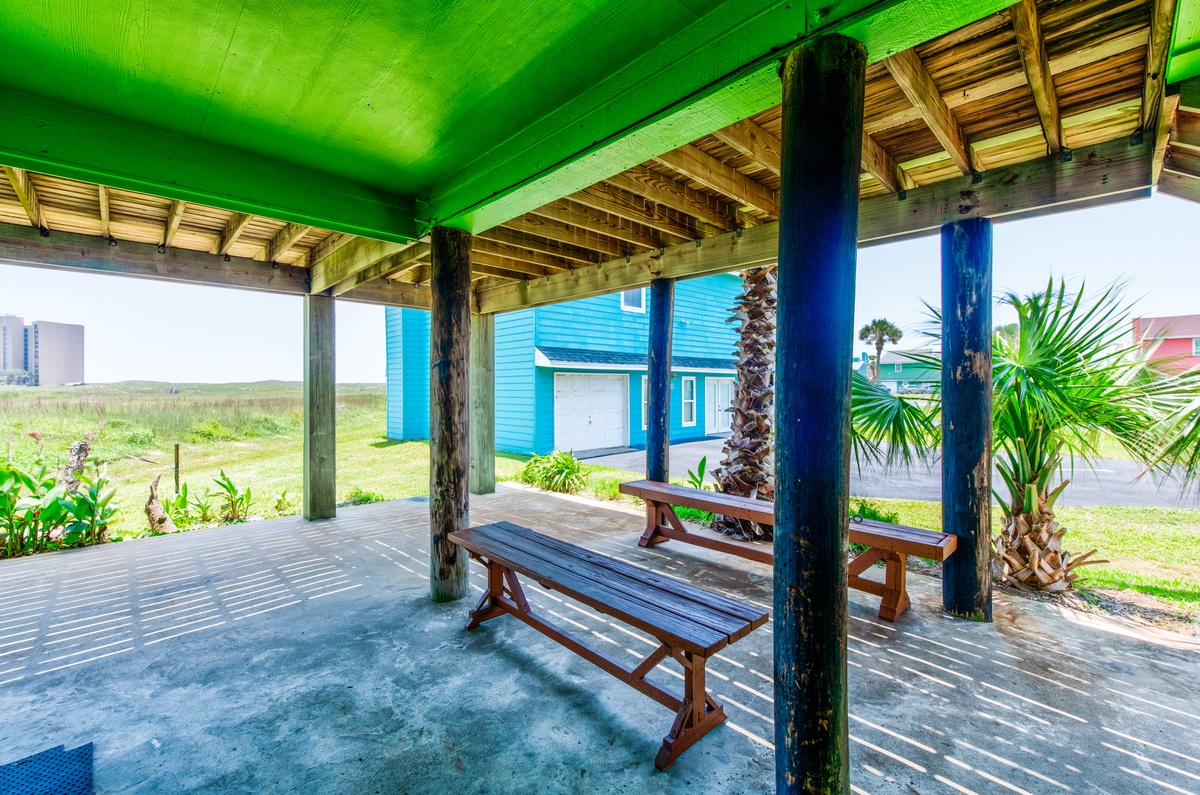 Relax on your covered patio with tropical palm trees and picnic tables, where cool shade meets warm coastal breezes.