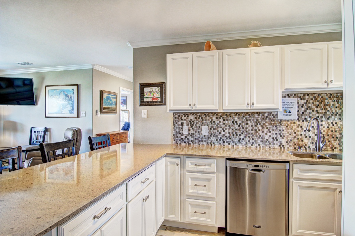 Your spacious kitchen awaits with gleaming granite counters, mosaic tile backsplash, and stainless appliances ready for memorable meals together.
