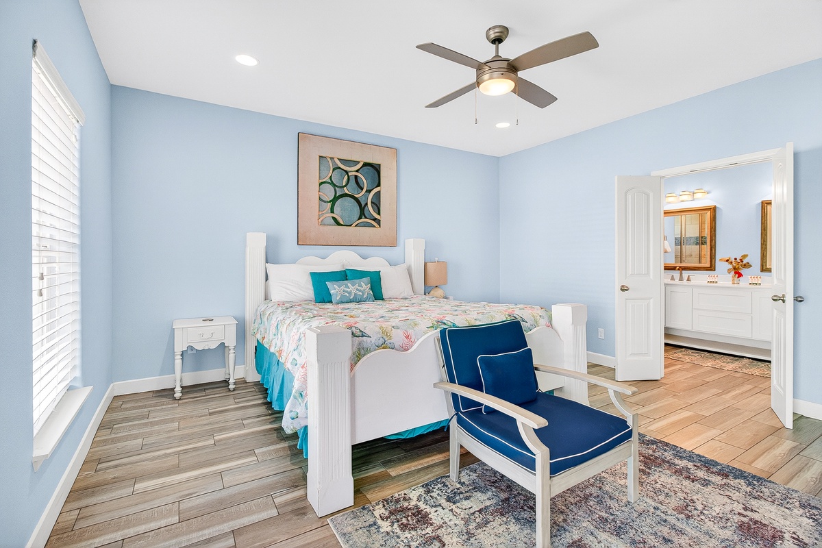 Drift off in your serene retreat with calming blue walls, comfortable bedding, and a ceiling fan for perfect temperature control.