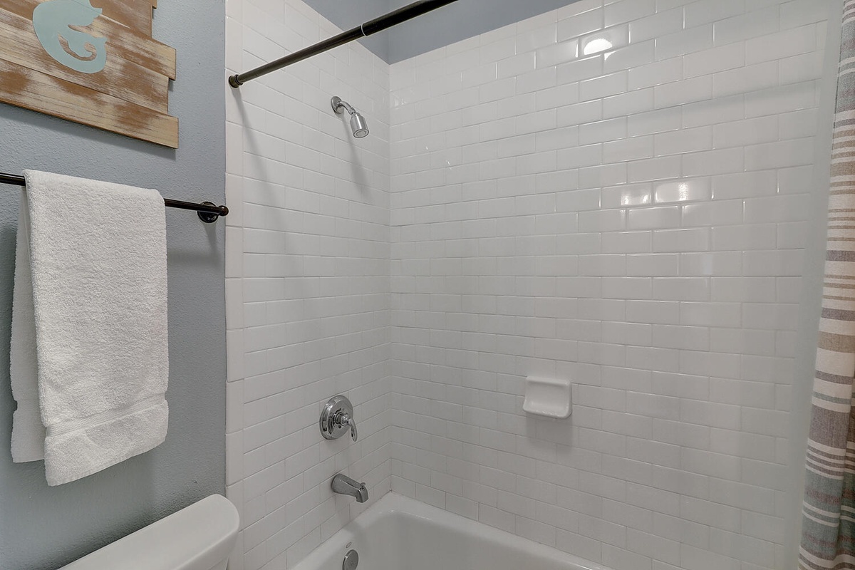 Step into your clean, modern bathroom with crisp white subway tile and fresh towels waiting for your arrival.