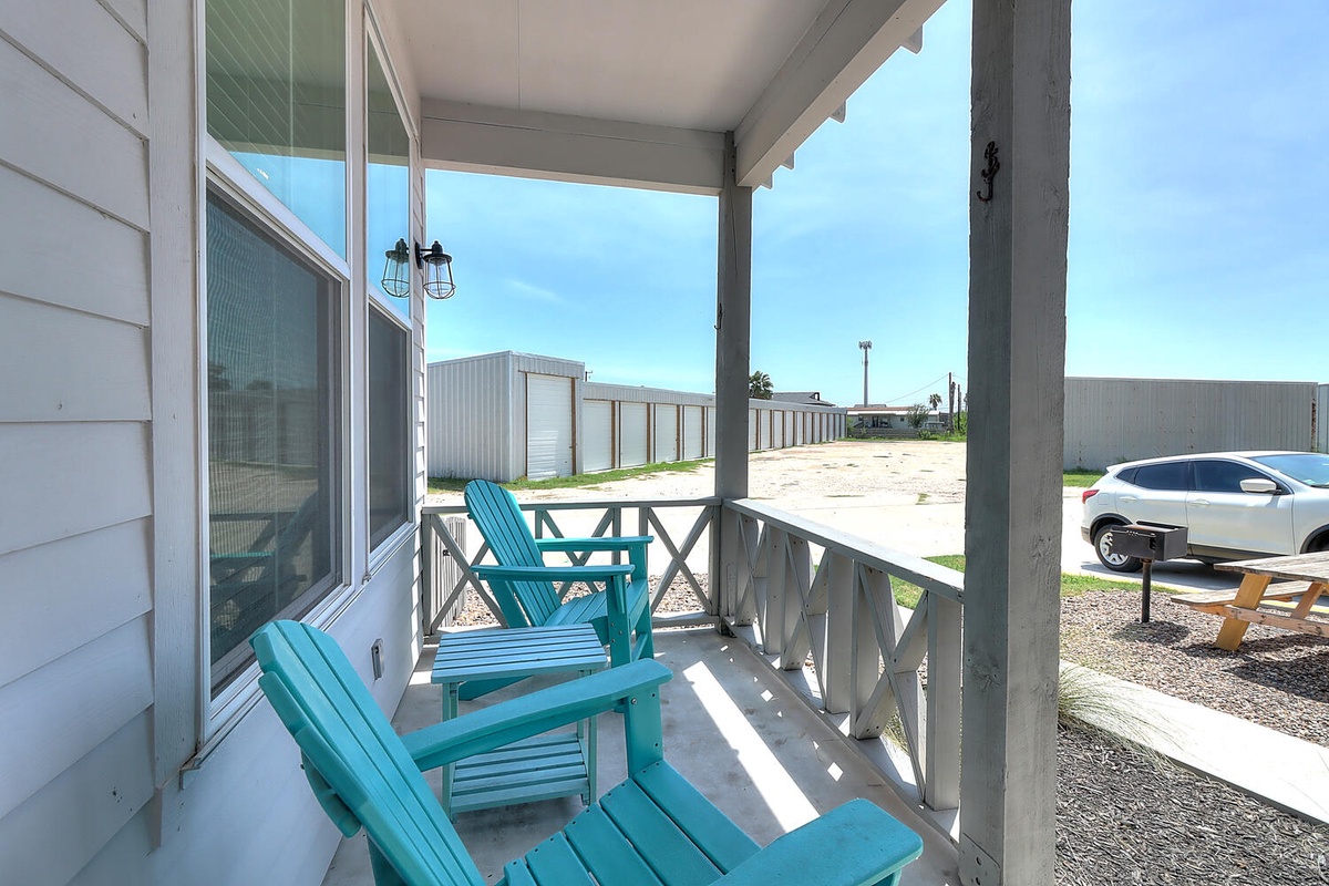 Settle into your private covered porch with turquoise Adirondack chairs, perfect for morning coffee or evening relaxation.