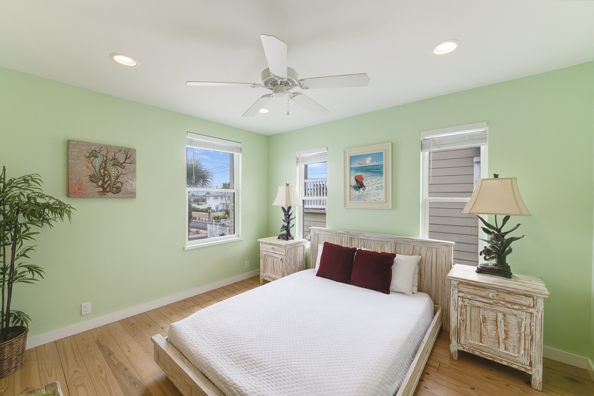Bright and inviting, this peaceful guest bedroom features soft coastal colors and comfortable furnishings for a relaxing night's sleep.