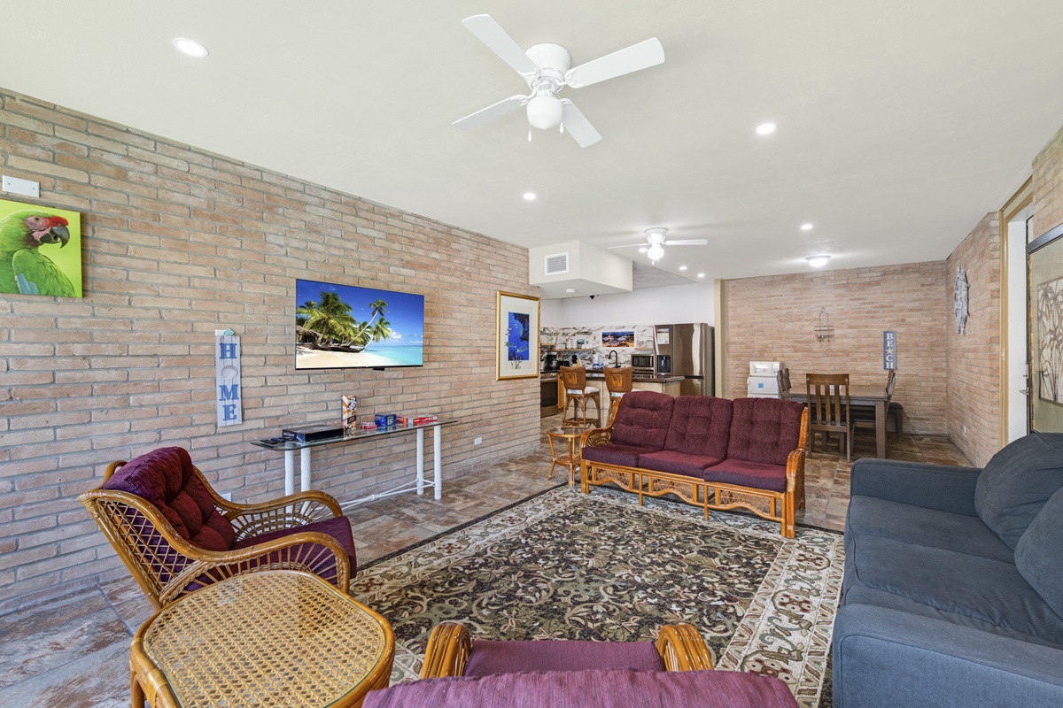 Unwind in this spacious living area, where exposed brick walls meet tropical comfort. Ceiling fans and bright lighting create an airy, welcoming atmosphere for your stay.