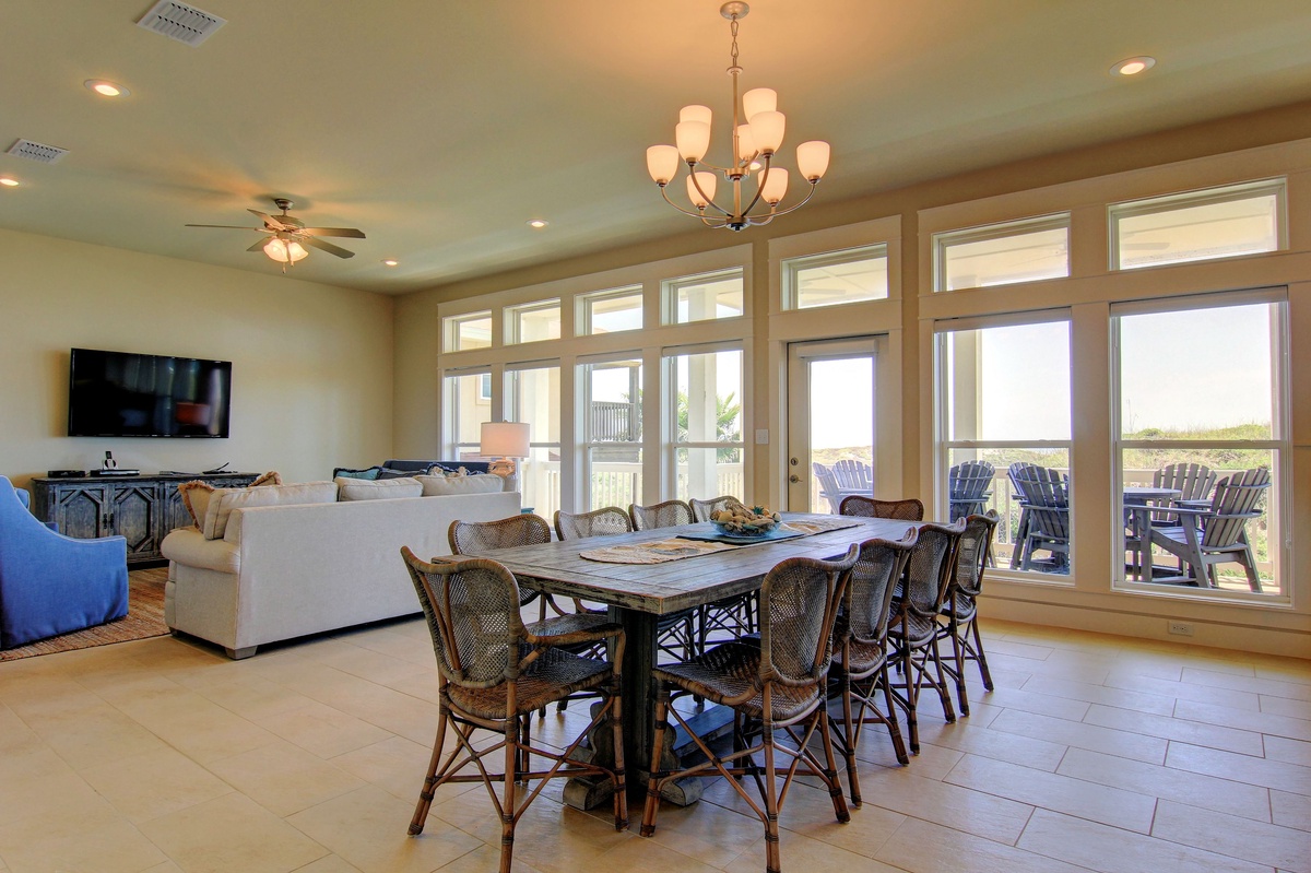 Gather around your expansive dining table for memorable meals while enjoying natural light through floor-to-ceiling windows and relaxing in the adjoining living area.