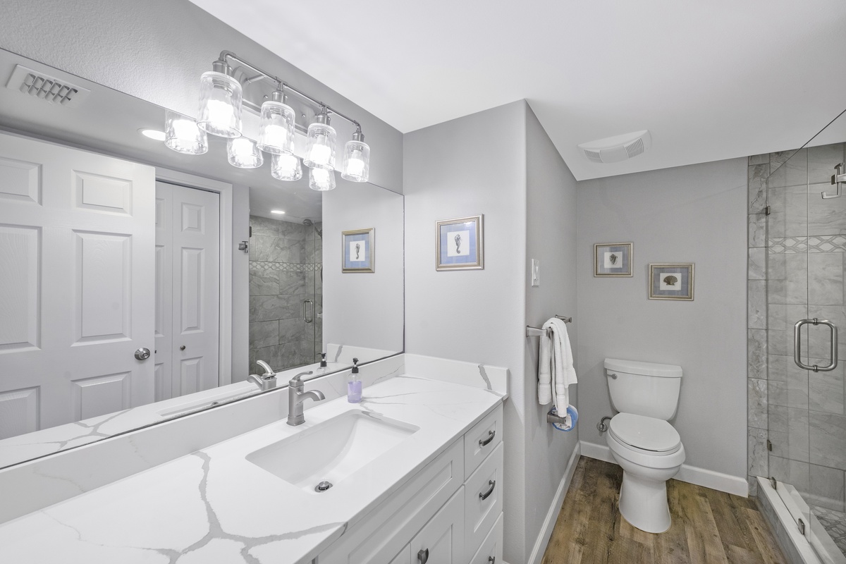 Your elegant bathroom features marble countertops, modern fixtures, and a spacious glass shower for ultimate comfort.