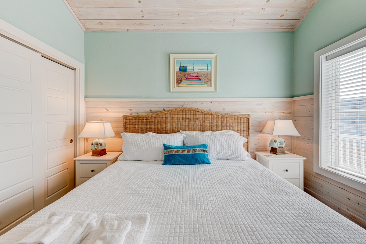 Drift off in this coastal retreat with soothing seafoam walls, warm wood accents, and crisp linens that invite peaceful dreams.