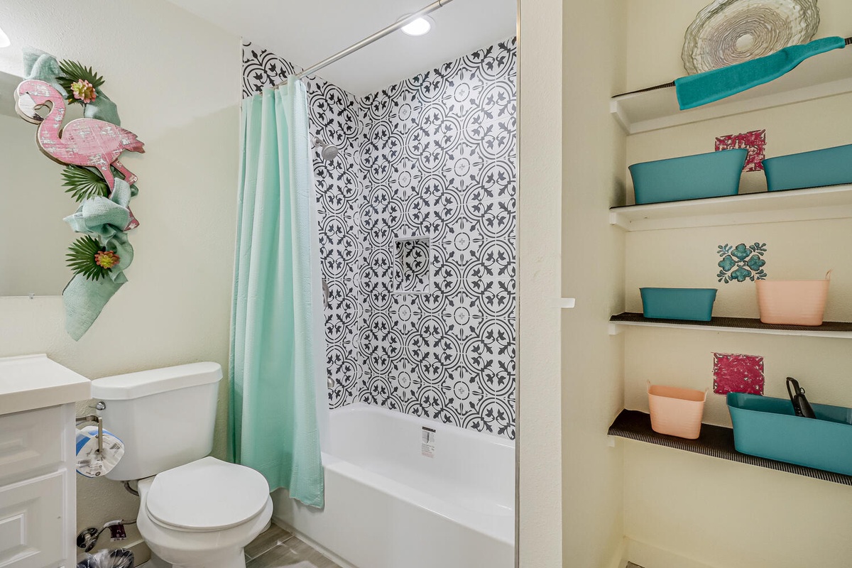 Your vibrant bathroom features tropical touches and organized storage shelves to keep your essentials beautifully arranged during your stay.