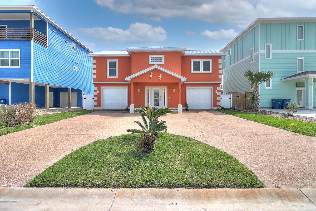 Bright coastal property with tropical palm and dual parking in a vibrant beachside neighborhood.