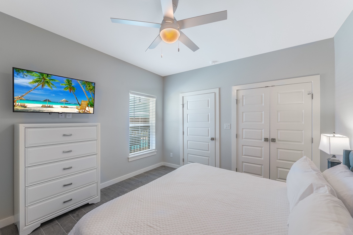 Unwind in your serene bedroom with a ceiling fan overhead, flat-screen TV, and ample storage in the spacious dresser.