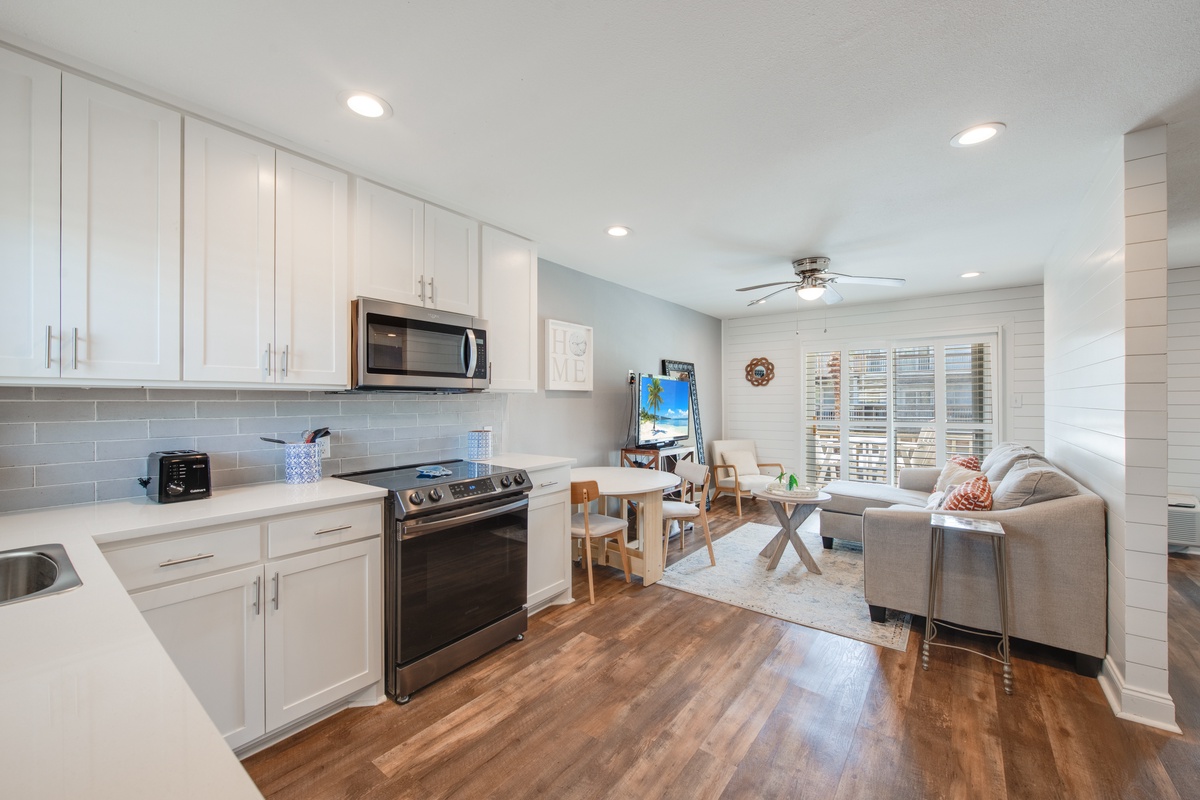 Your stylish open-concept space flows seamlessly from modern kitchen to cozy living area, with gleaming floors and bright windows creating the perfect home base.