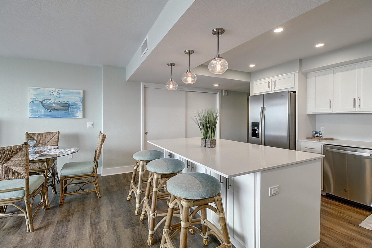 Cook meals together in your bright, modern kitchen featuring a spacious island and stylish pendant lighting.