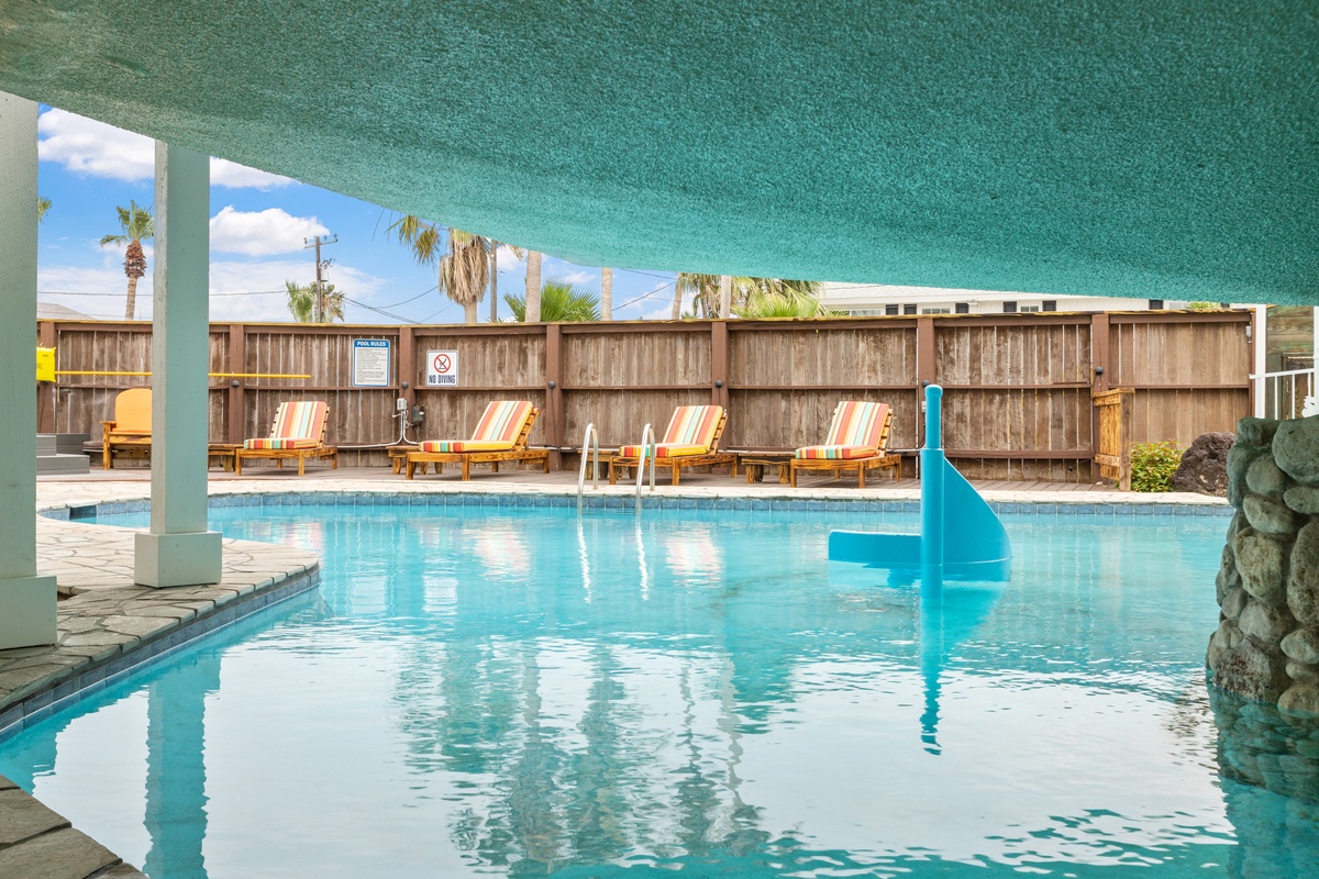 Slip into crystal-clear waters and lounge on colorful chairs by your private pool oasis, where tropical relaxation awaits under endless blue skies.