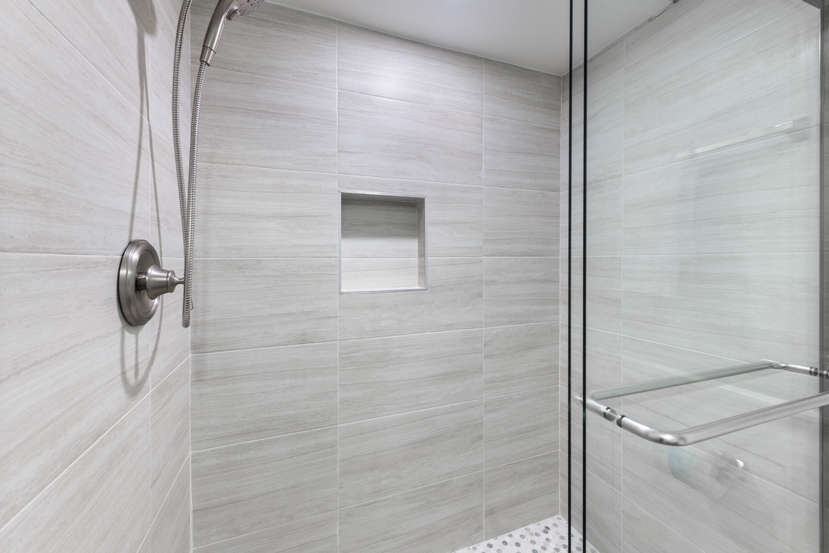 Step into your modern shower with sleek gray tiles and rainfall showerhead for a refreshing start to each day.